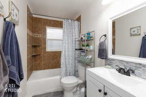 Full bath featuring shower / tub combo, vanity, and backsplash