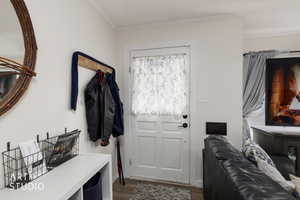 Mudroom featuring dark wood-style floors and ornamental molding