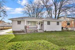 View of front facade with covered porch and a shingled roof