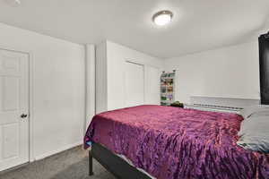 Bedroom with carpet flooring, a closet, and a textured ceiling