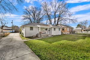 View of front of house with concrete driveway, roof with shingles, and covered porch