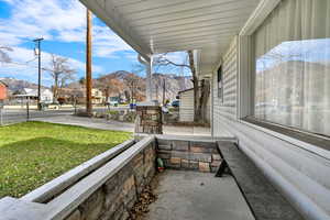 Porch featuring a mountain view, a residential view, and a lawn