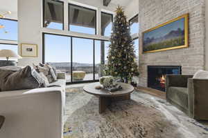Living room with a fireplace, wood finished floors, a high ceiling, and a mountain view