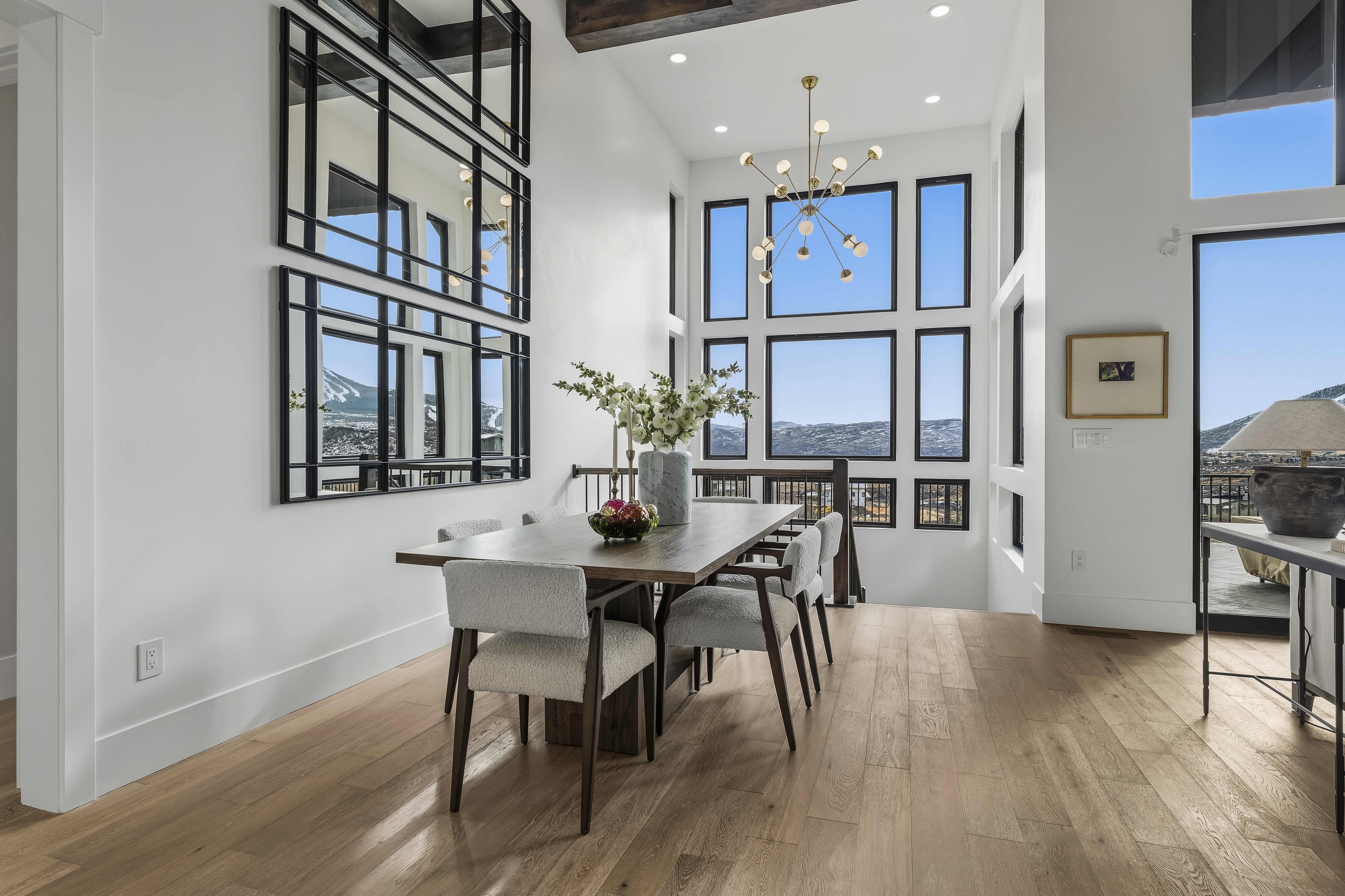 Dining space with a chandelier, light wood-type flooring, plenty of natural light, recessed lighting, and a towering ceiling