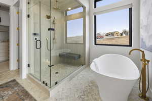 Full bath featuring a soaking tub, a shower stall, and a walk in closet