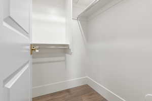 Walk in closet with wood finished floors