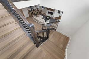 Stairway featuring wood finished floors and a high end fireplace