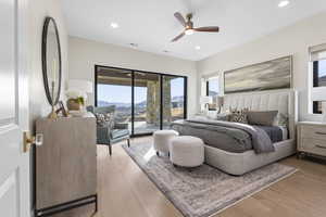 Bedroom with access to outside, light wood-style flooring, a ceiling fan, recessed lighting, and a mountain view
