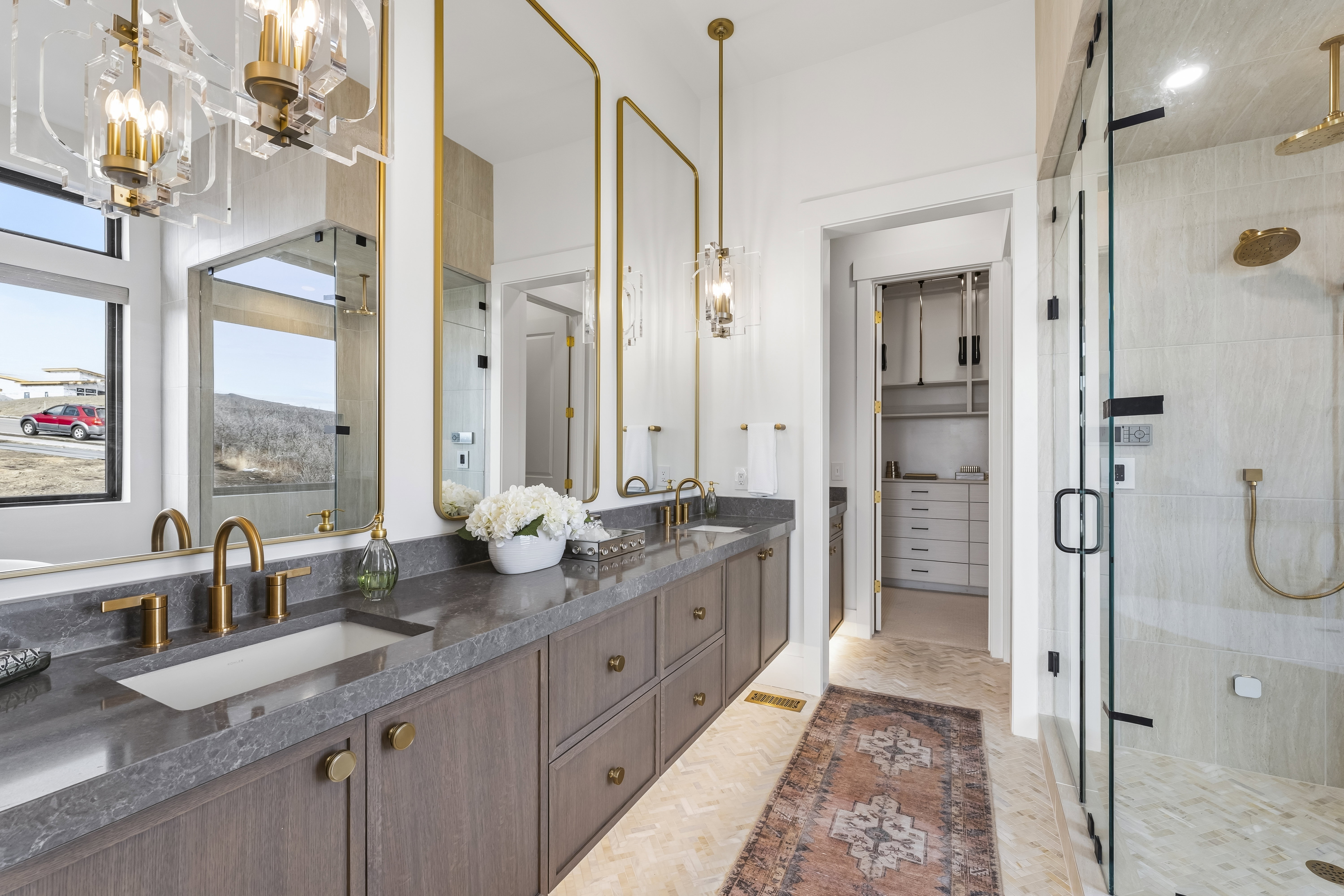 Full bathroom with double vanity, a shower stall, a chandelier, and a spacious closet