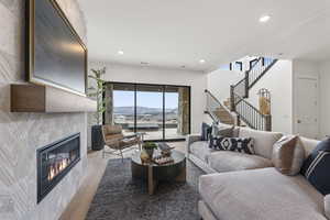 Living area featuring plenty of natural light, light wood-style floors, recessed lighting, a mountain view, and a fireplace