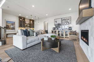 Living area featuring a tile fireplace, recessed lighting, and light wood finished floors