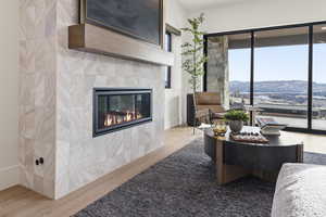 Living room featuring wood finished floors, a tile fireplace, and a mountain view