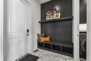 Mudroom with washer / dryer and light marble finish flooring