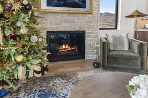 Living area featuring wood finished floors and a glass covered fireplace