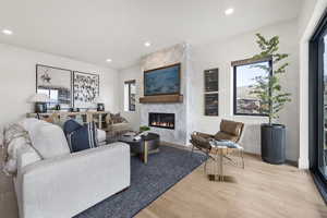 Living area with light wood-style flooring, a fireplace, and recessed lighting