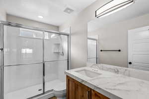 Bathroom with a shower stall and vanity