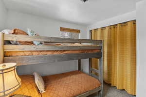 Bedroom featuring a textured ceiling, a closet, and carpet