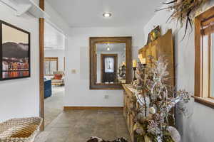 Corridor featuring healthy amount of natural light and dark carpet