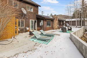 Back of house with an outdoor fire pit, a patio area, and a chimney