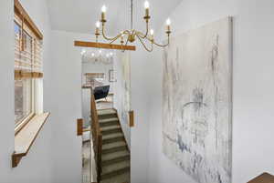 Stairway featuring a chandelier