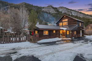 View of front facade with a mountain view, a metal roof, and board and batten siding