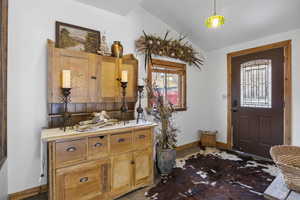 Foyer featuring vaulted ceiling and tile patterned floors