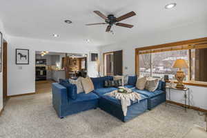 Living area featuring a ceiling fan, recessed lighting, and carpet flooring