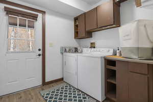 Laundry area featuring cabinet space, light wood-type flooring, and washer and dryer