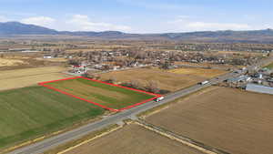 Aerial view of sparsely populated area with property boundaries highlighted, mountains, and abundant farmland