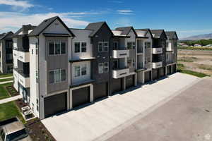 View of front facade with an attached garage, a residential view, board and batten siding, and concrete driveway