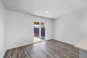 Spare room with dark wood-style floors and baseboards