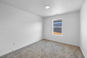 Carpeted empty room with baseboards and a textured ceiling