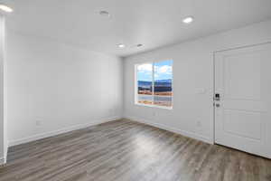 Foyer entrance featuring light wood-style floors, recessed lighting, a textured ceiling, and a mountain view