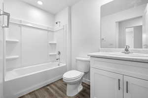 Full bath with  shower combination, vanity, and dark wood-style flooring