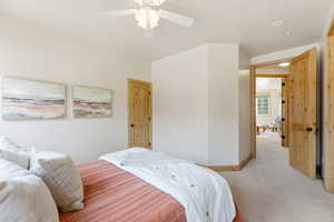 Carpeted bedroom featuring baseboards and ceiling fan
