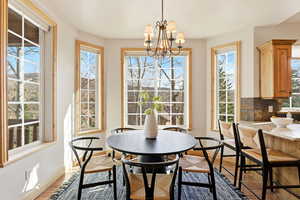 Dining area with wood finished floors and a chandelier