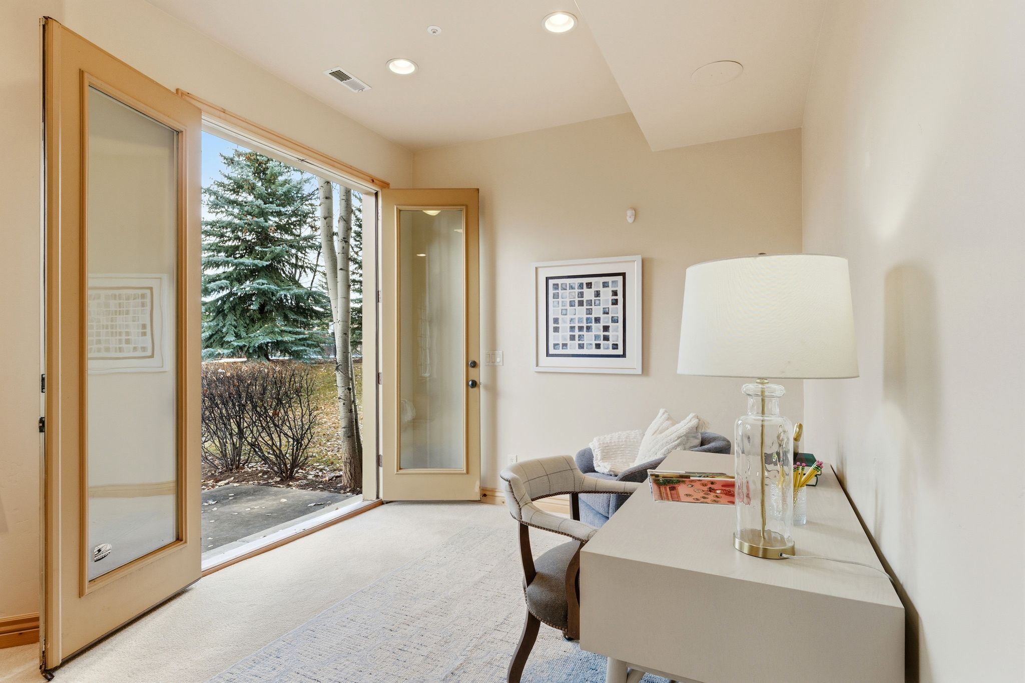 Office space with light carpet and recessed lighting