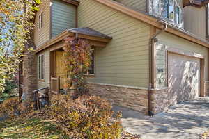 View of property exterior featuring an attached garage and stone siding