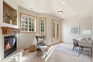 Carpeted home office featuring french doors, recessed lighting, and a glass covered fireplace