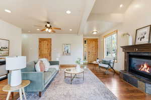 Living area featuring healthy amount of natural light, hardwood / wood-style floors, recessed lighting, a fireplace, and a ceiling fan
