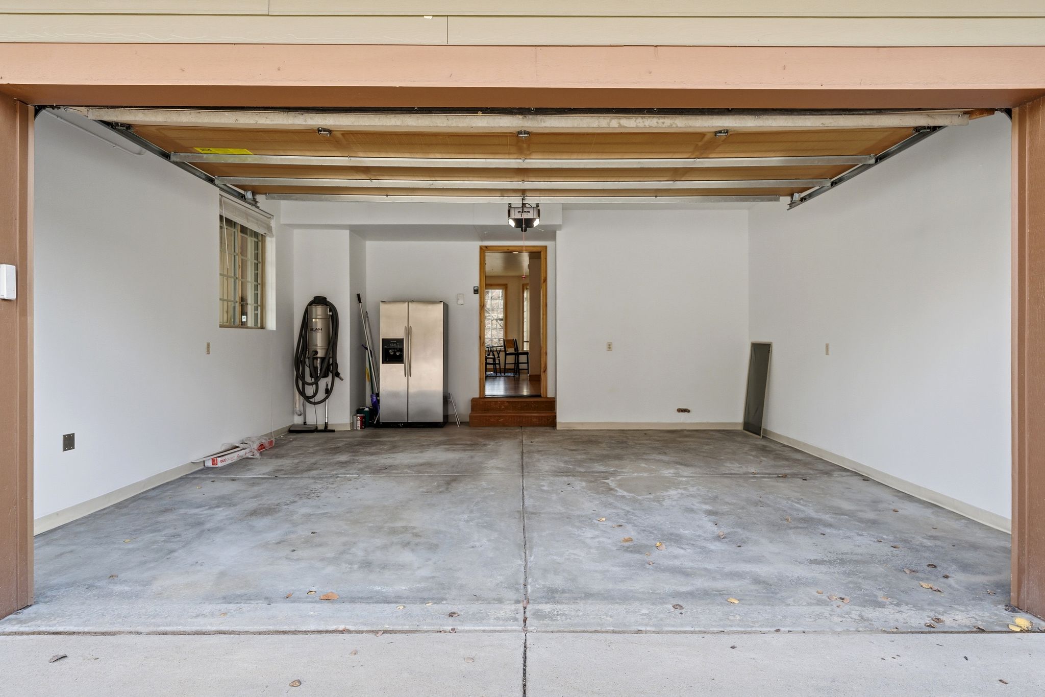 Garage with stainless steel fridge with ice dispenser and a central vacuum unit