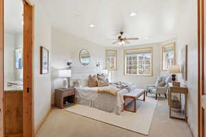 Bedroom with multiple windows, ceiling fan, light carpet, and recessed lighting