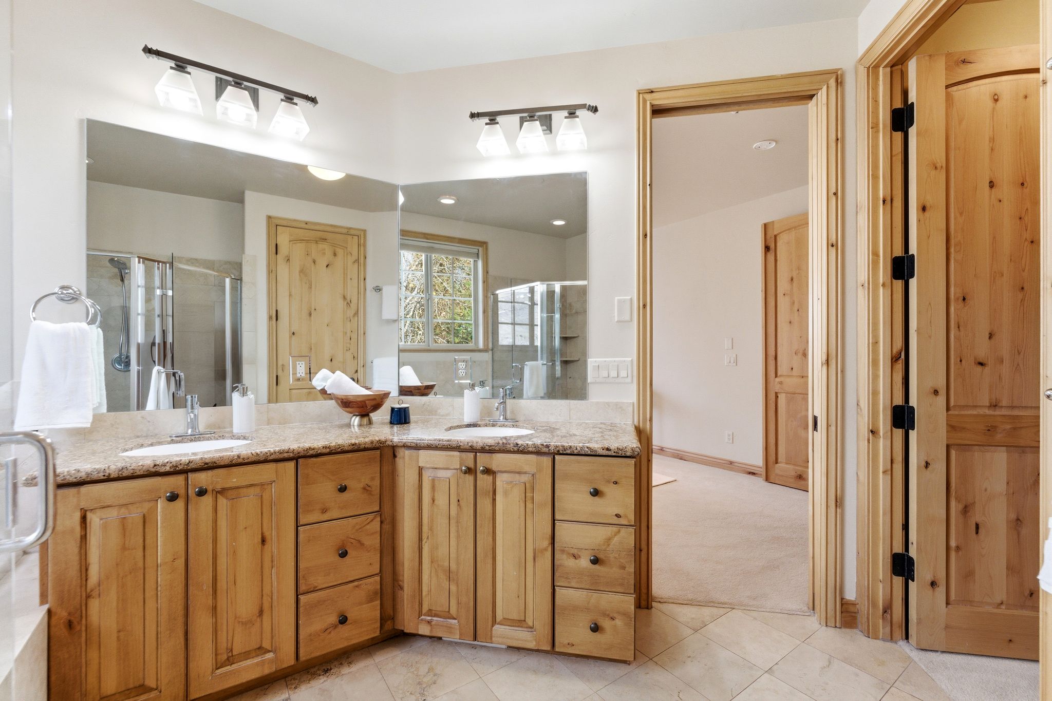 Bathroom with double vanity, a stall shower, and light carpet