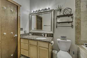 Full bath with vanity, a bathtub, and a textured wall