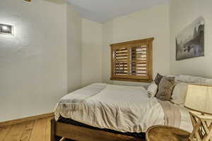 Bedroom with baseboards and hardwood / wood-style floors