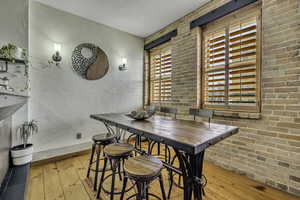 Dining area featuring hardwood floors, and brick wall