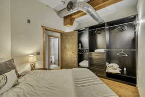 Bedroom with a closet, a textured wall, and light wood-style flooring