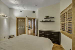 Bedroom featuring light wood finished floors and a textured wall
