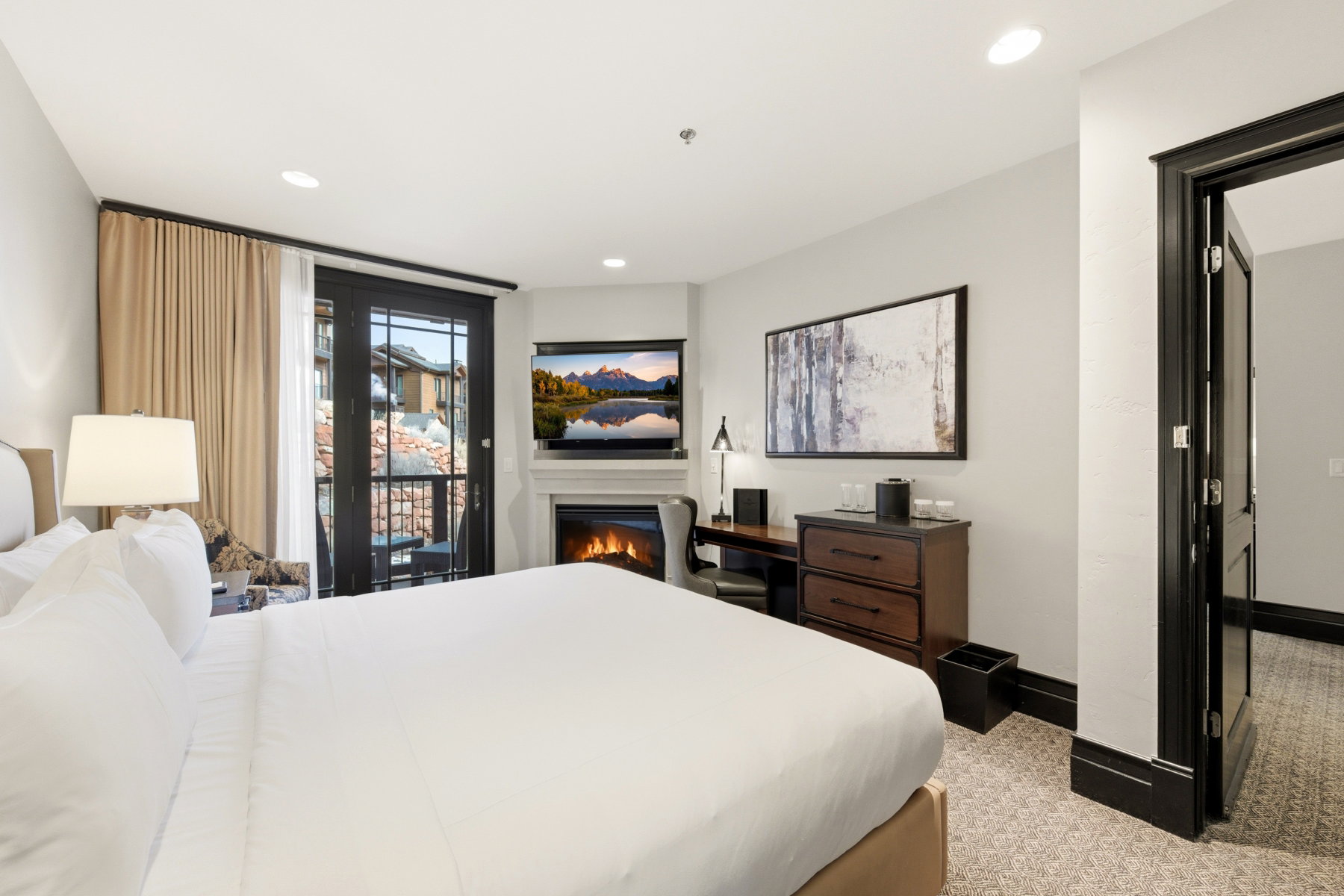 Bedroom with access to exterior, a glass covered fireplace, recessed lighting, and light colored carpet