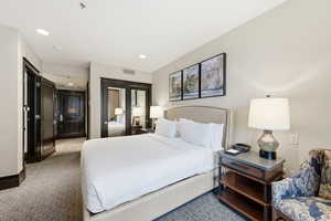 Bedroom featuring a closet, recessed lighting, and light carpet